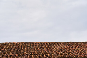An old tiled roof against the sky as a background.
