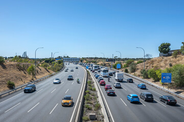 Toll road with long lines of vehicles waiting to pay at automated booths
