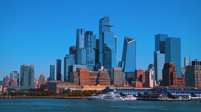 Boats stand at the pier of the East River. Spectacular glass skyline of New York from the riverscape.