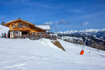 traditional wooden alpine restaurant situated on a snow-covered ski slope