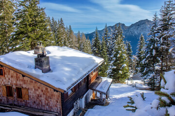 traditional wooden chalet or cabin nestled on a snowy slope, in the Austrian Alps