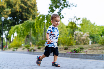 Smiling run through the park lanes. Captured mid‑step, the child runs with a happy grin along the garden path, enjoying open space and fresh air.