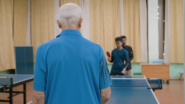 Coach observes two young players switching positions during doubles table tennis game, highlighting teamwork, coordination, training, strategy, and focus in indoor practice session