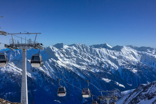Alpine gondolas ascend high snowy mountains
