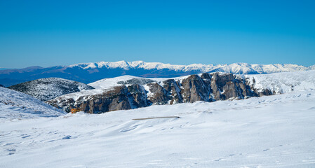 Snow covered Făgăraș Mountains, the highest mountains of the Southern Carpathians, Romania under a bright blue sky