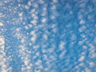 Clear blue sky with soft white clouds creating a peaceful and dreamy sky background