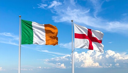 Two flags flying on flagpoles against a bright blue sky