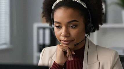 A thoughtful Black call center agent with a headset, listening intently to a customer. This footage is perfect for serious support concepts