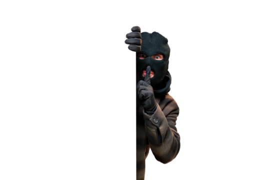 Thief wearing a black balaclava peering from behind a white blank sign, signaling silence with a finger over lips