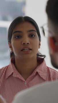 Vertical video young indian female physician leading a diverse medical team discussion on patient diagnosis and treatment plan in hospital office