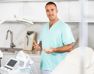 Beside cosmetology chair, physician standing near professional hydrogen oxygen facial machine.