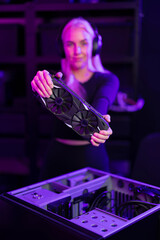 Female gamer in her twenties upgrades a gaming PC by installing a graphics card