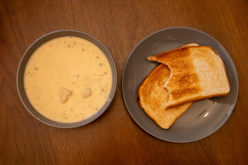 Homemade Potato and Bacon Soup with Sourdough Toast on Wooden Table