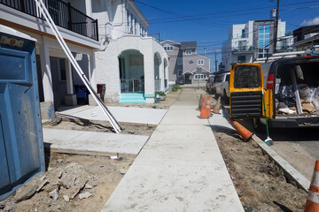 Front on a newly constructed house with new concrete sidewalks but no grass or shrubs