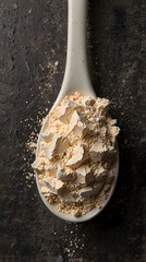 Whey protein scoop filled with fine powder on dark background
