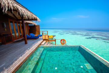 Tranquil closeup calm sea water waves with palm trees. Cabin with pool. Tropical island beach landscape exotic shore coast. Summer vacation, holiday amazing nature. Relax paradise, Maldives.