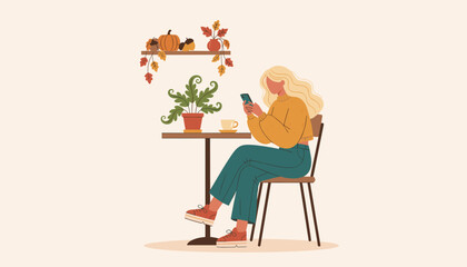 Young woman texting on phone at cafe table decorated for autumn enjoying coffee break