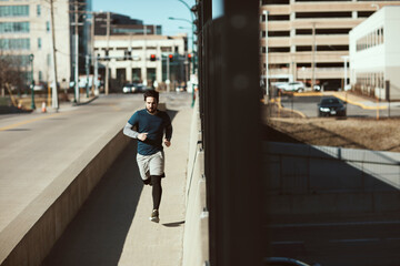 Young adult man jogging in urban area