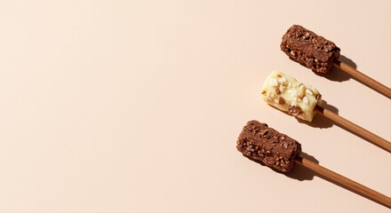 assorted chocolate cereal bars on sticks on a beige background with copy space for text