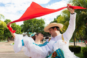 A Latina couple is dancing the traditional Sanjuanero in a plaza in downtown Neiva, Huila, Colombia. Concept of Colombian culture and happiness