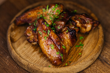 Grilled chicken wings with herbs on wooden plate