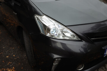 Headlight of a black car, close-up view, automobile trade and production. Xenon lamp.