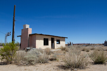 Abandoned structure made from hollow cinder blocks of concrete with a fireplace and chimney in the middle of the desert