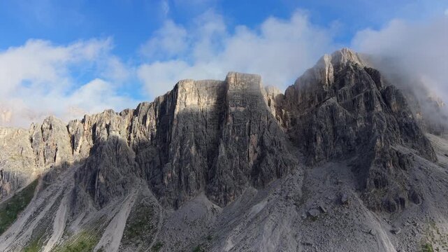 Stunning aerial view flying backwards from the rocky peaks of Croda da Lago in the Italian Alps