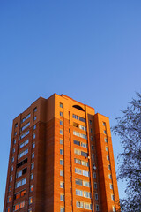 Sunny afternoon view of a tall residential building against a clear blue sky