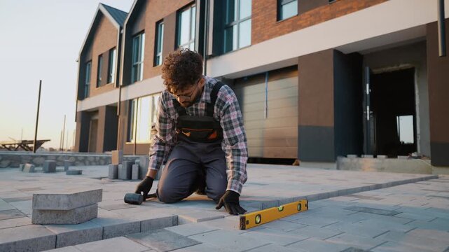 Professional paver laying concrete paving slabs