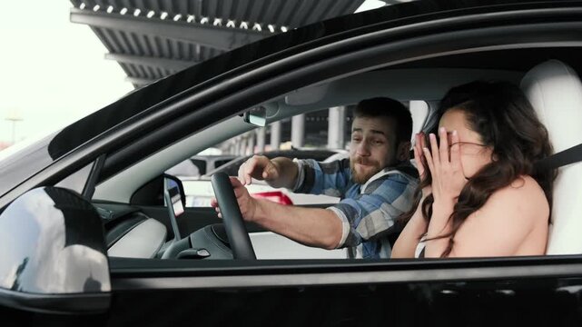 Lady learning how to drive car together with male instructor. Slow motion
