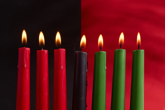 African American Kwanzaa holiday concept with traditional lit candles. Seven candles red, black and green