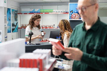 Obraz premium Senior man patient consults female cashier at the apothecary counter, receiving assistance with prescription medicine, dosage recommendation and the selection of pharmaceutical drugs.