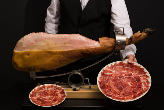 Jam&oacute;n sobre jamonero preparandolo para limpieza y corte con emplatado.