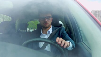 Successful young businessman getting into car and using seat belt while driving in the city. Transport, business and people concept. Slow motion