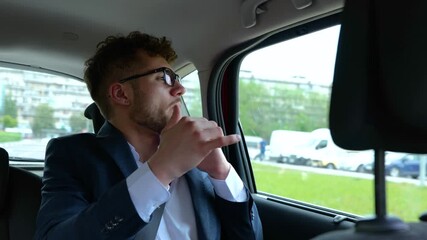 Male passenger in the back seat of taxi car listening to music on the radio and dancing, enjoying the trip. Business, trip, transport and lifestyle concept. Slow motion