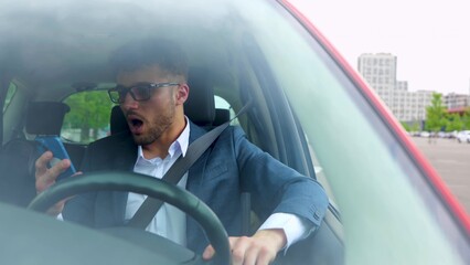 Successful young businessman in glasses sitting in car while talking on mobile phone. Transport, business, technology and people emotions concept. Slow motion