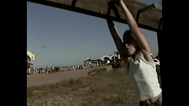 Child plays on monkey bars at old playground in retro vhs 90s style