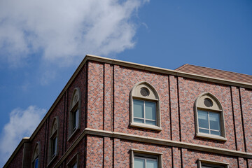 Red brick building with arched windows under blue sky