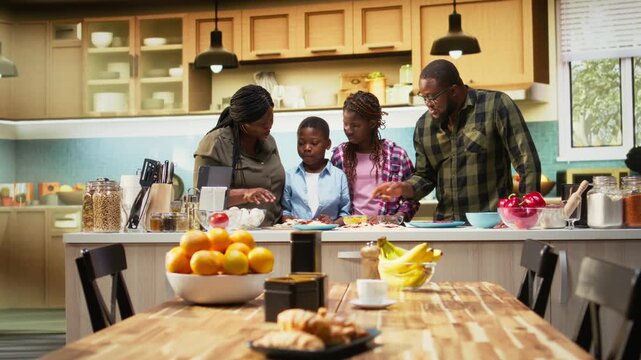 Portrait of parents teaching their kids how to make homemade pizza with fresh ingredients, offering advice and assistance step by step. Family bonding and having fun over culinary hobby. Camera A.