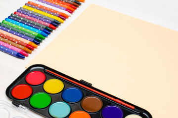 Watercolor paints, colorful pencils, pastel crayons,blank watercolor paper pad. Creativity creation process. Artist's stuff on white table.Top view Flatlay of drawing supplies