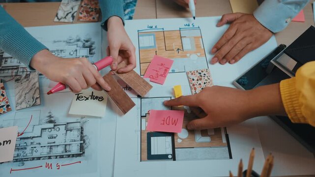 Hands engaged in a creative design process, showcasing colorful notes and textures alongside architectural plans in a collaborative workspace setting. SACTR