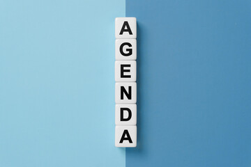 Agenda word on dice on blue and gray background
