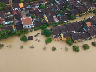 The deepest flood in history in Hoi An, Da Nang 2025. Aerial view of flooded ancient Asian town with yellow houses and brown roofs, showing severe urban flooding and climate disaster impact © jangnhut
