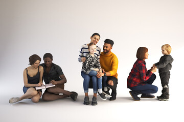 Diverse couples and children are on a white background acting naturally.