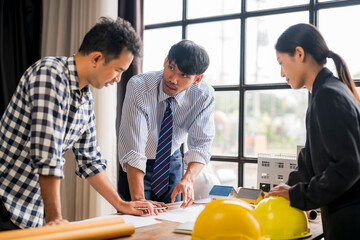 Engineers and architects discussing over blueprint of solar house project in office meeting
