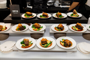A gourmet presentation of short ribs plated with creamy mashed potatoes, crisp green beans, and a drizzle of rich sauce — a symphony of color, texture, and fine dining elegance