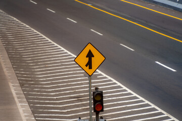 Intersection near a toll gate entrance in Indonesia. The road features white and yellow lane markings with a striped pattern on the side lane