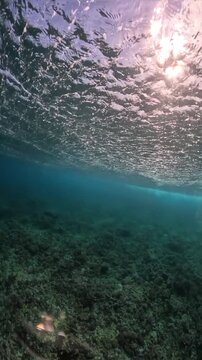 Underwater view of a surfer riding a powerful wave at Cloudbreak in Fiji. Video showing the rolling wave and dynamic motion from an underwater perspective.