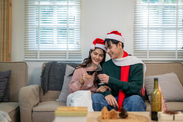 Young couple celebrating christmas toasting red wine